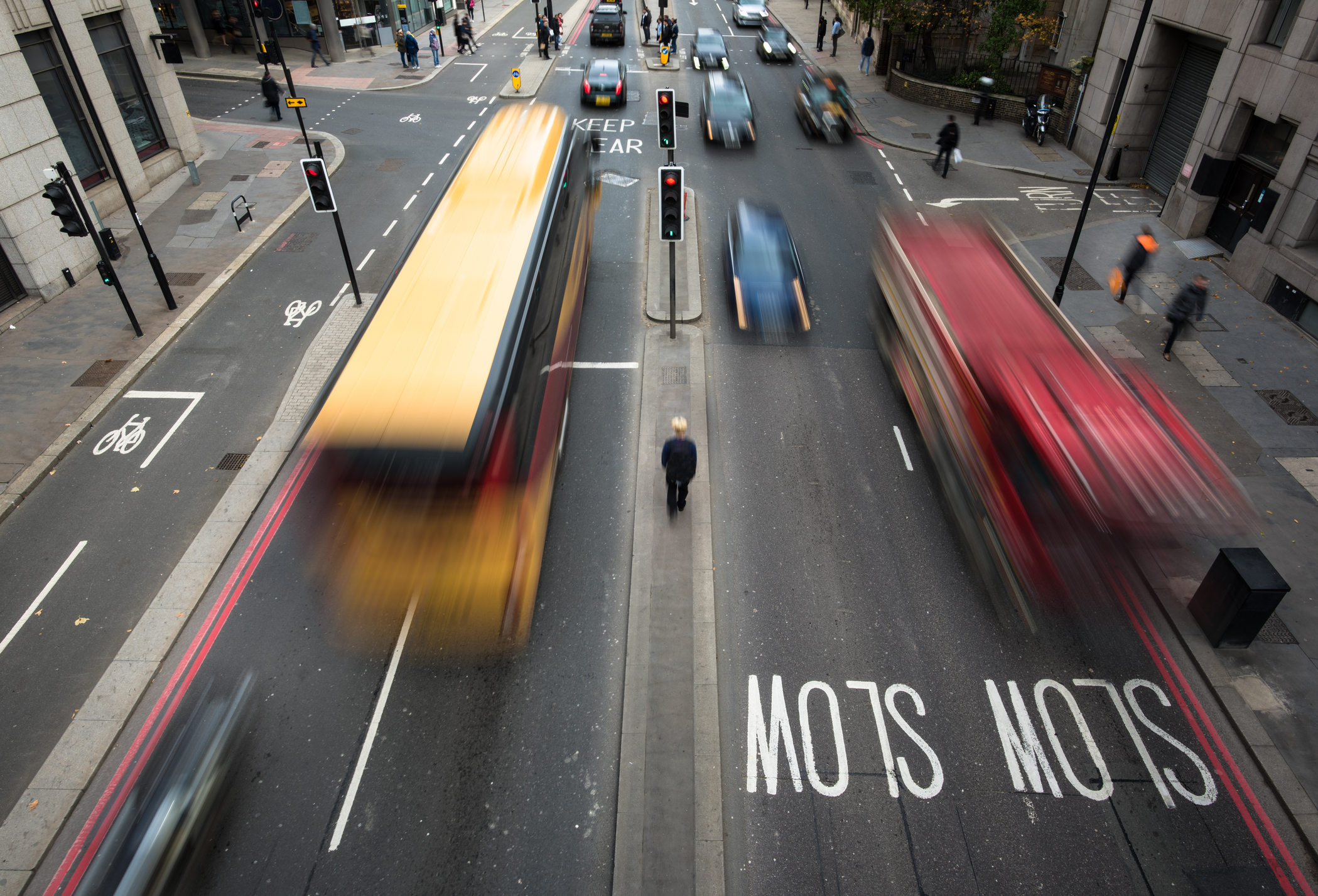 High Angle View of Blurred Vehicles and Man Walking between Traffic on a Busy City Street. London. UK.