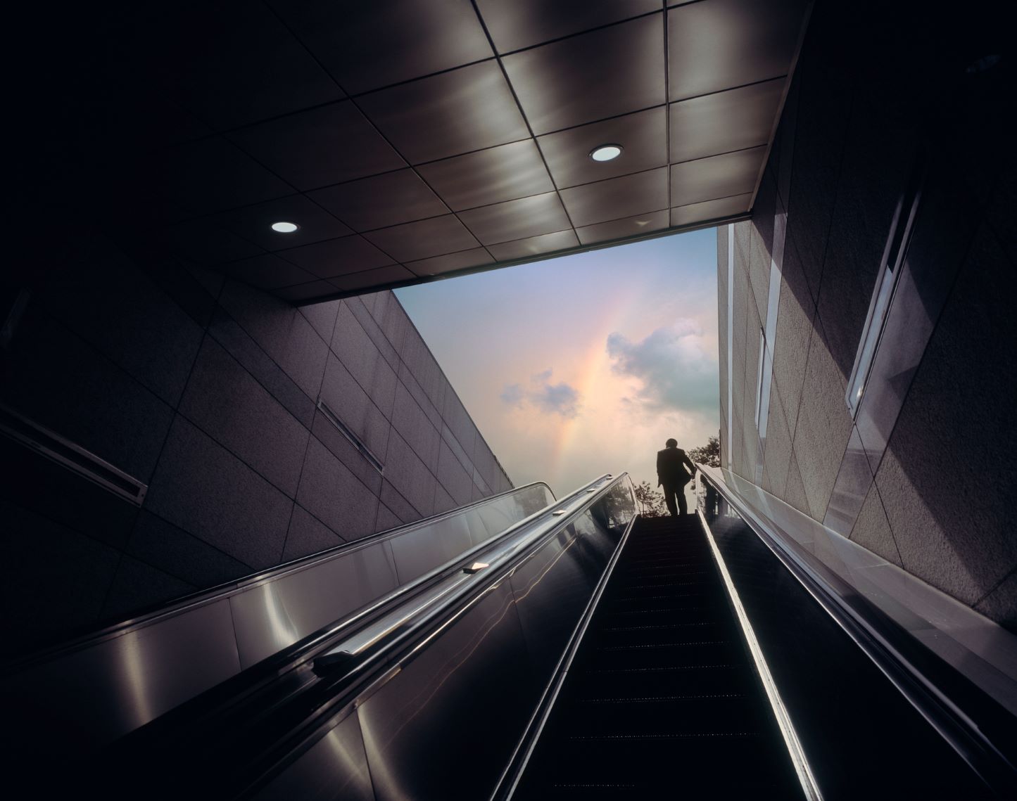 Businessman exiting on an escalator