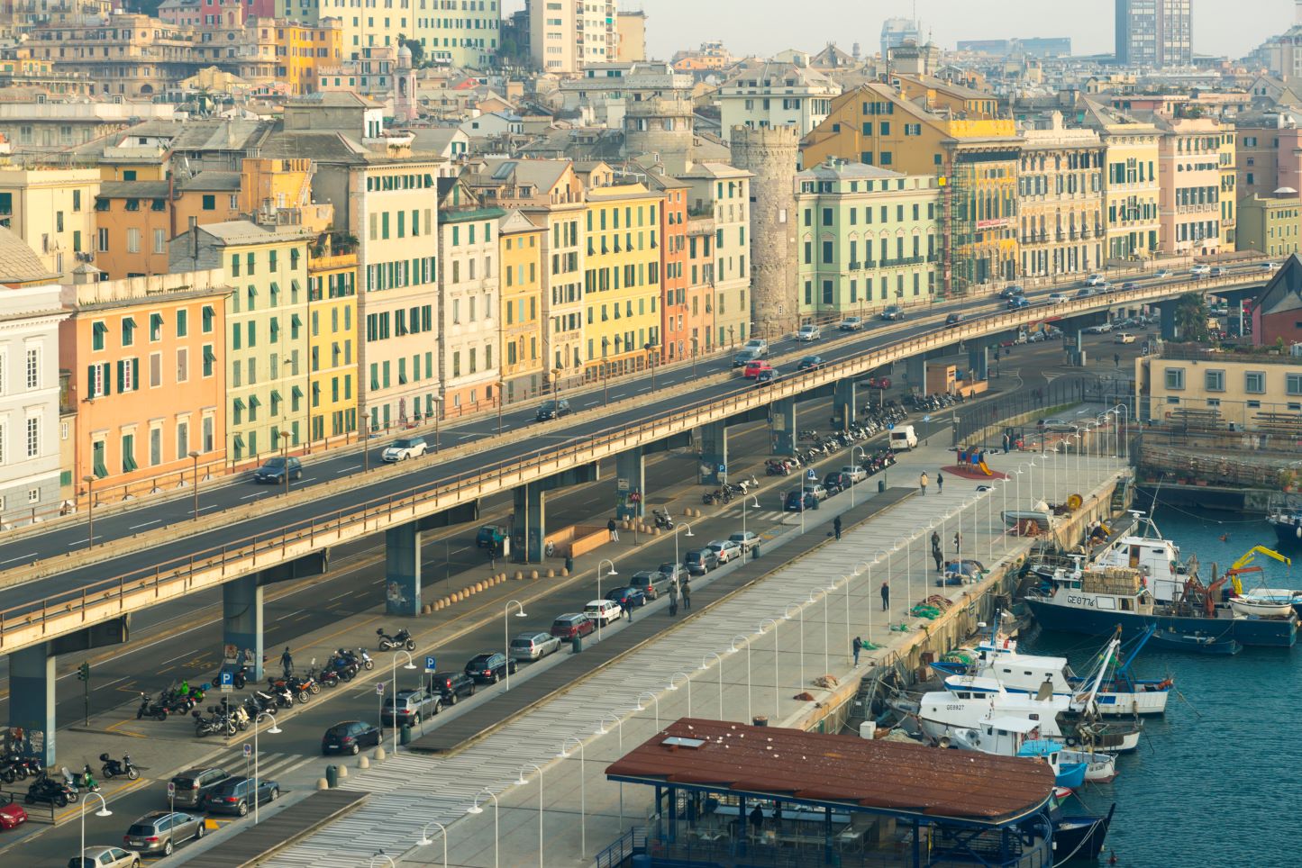 A causeway between buildings and the harbor in Genoa, Italy